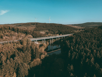 Fast schon unwirklich -wie eine Fotomontage- steht die Talbrücke Landeskroner Weiher im Wasser. Dazu der grenzenlose Ausblick über die Baumwipfel des Siegerlandes. Die in Wirklichkeit imposante Brücke fügt sich aus der Vogelperspektive wie selbstverst